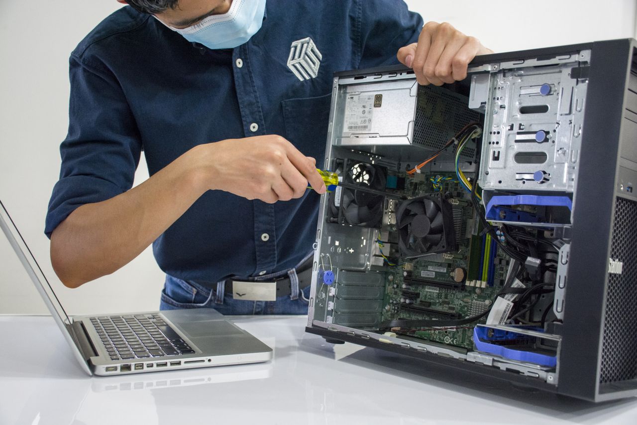 The Art of Drawing Readers In: Your attractive post title goes here A technician repairs a desktop computer in an indoor setting, illustrating tech maintenance.