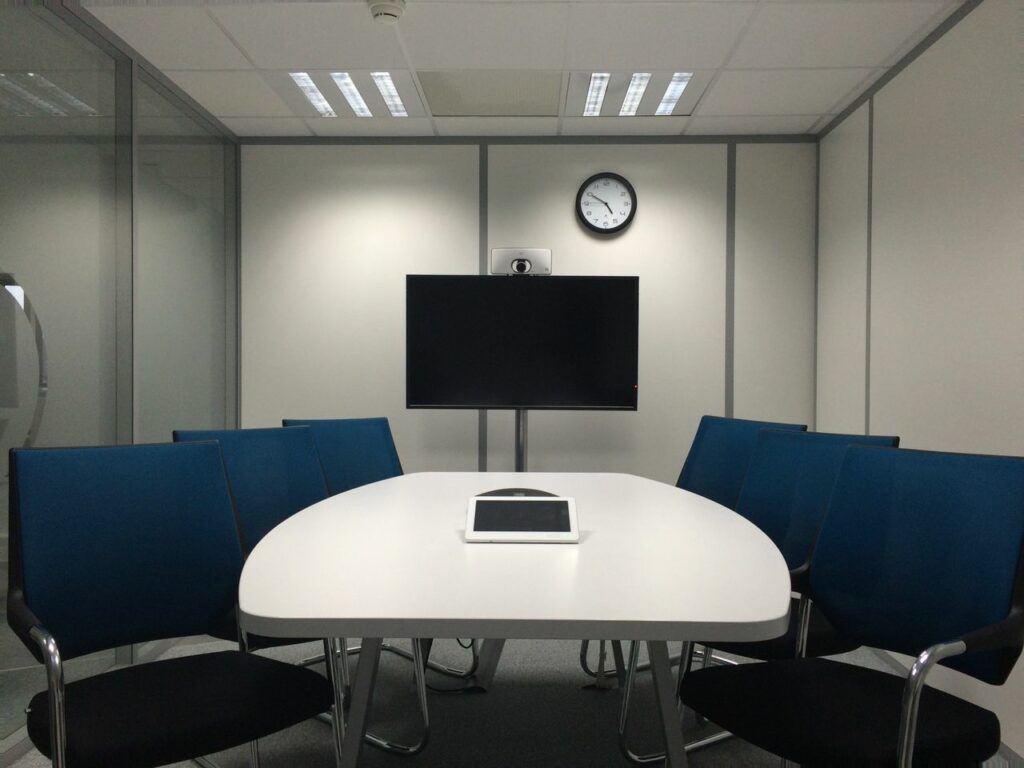 pexels photo 236730 236730 Sleek conference room with a table, chairs, TV, and video conferencing equipment.
